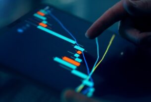 Finger pointing at a digital chart on a tablet showing financial trends and fluctuations.